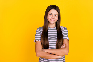 Obraz premium Portrait of attractive cheerful curious long-haired girl folded arms thinking copy space isolated over bright yellow color background