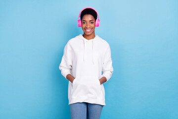 Photo of beautiful charming unisex lady dressed white hoodie headphones arms hands pockets isolated...