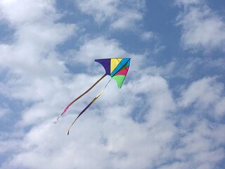 Colorful kite floating on the cloudy sky