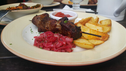 Shish kebab fried potatoes and salad closeup