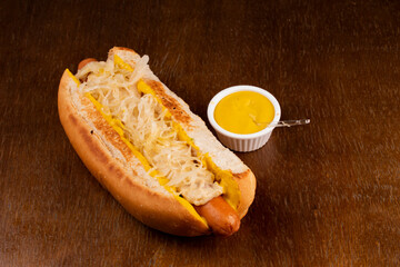 oktober fest typical german hot dog with yellow mustard sausage, sauerkraut in wooden emsa and top view