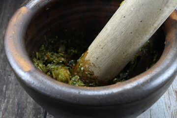 Traditional clay mortar and wooden pestle, famous kitchen tool in Asia kitchen. 