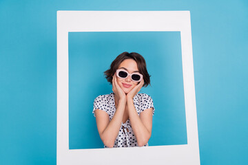 Portrait of adorable calm girl arms on cheeks paper album card isolated on blue color background