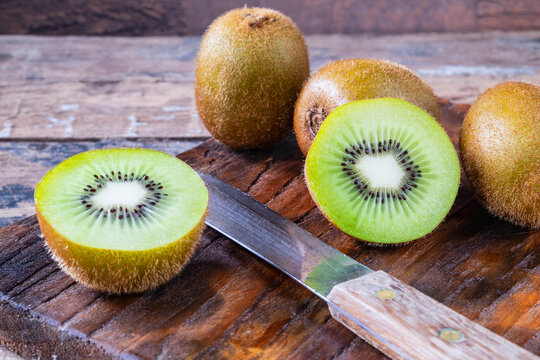 Fresh Kiwifruit Cut In Half On A Wooden Cutting Board.