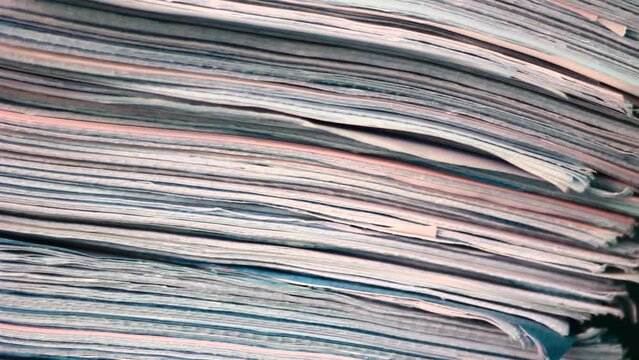 Close up of files, papers, newspapers in a stack on the desk.