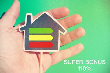 Human hand holding a house with energetic graph and the text 
