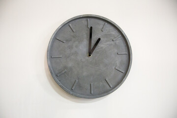 Concrete minimalist clock on a white wall.