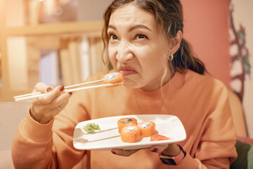 a woman sniffs a spoiled sushi roll. The danger of poisoning and the shelf life of food