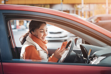 A female taxi or carsharing driver looks into her smartphone app to accept a call or navigate...