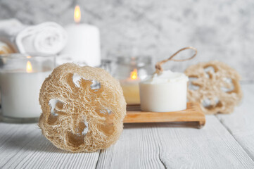 Natural loofah scrubber on podium in bathroom. Zero waste in life. Relaxation spa concept, candles, beauty..