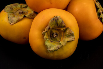 Persimmon - Fresh Kaka fruits isolated in extendable black background with shadow and water drops on it crystal clear macro details, shot using studio lights and macro lens.
