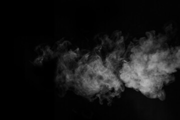 Swirling, wriggling smoke, steam, isolated on a black background for overlaying on your photos. Fragment of horizontal steam