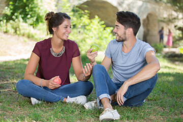 young couple eating apples outdoors