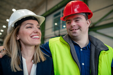 Young man worker with Down syndrome with manager working in industrial factory, social integration...