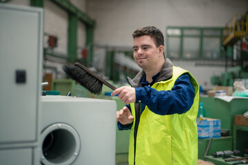 Young man with Down syndrome working in industrial factory, social integration concept.