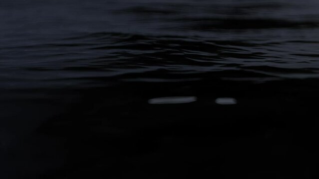 A Marine surface at dark dawn, The Loop Footage with Background texture of ocean night water close up. Great copy space area for cinematics titles or presentation.