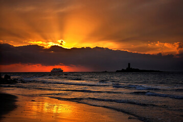 Sunset at Kafkalida beach, close to Kyllini, Ileia prefecture, Peloponnese, Greece. In fact, Kafkalida is the name of the islet with the lighthouse. The ship is coming from Zante island.