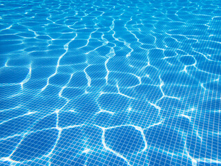 Swimming pool bottom under the water. Sunlight reflection of transparent clear water surface. Selective focus, copy space. Texture, background