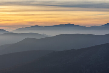 Naklejka na ściany i meble Stunning sunset over foggy Old mountain, Bulgaria. Landscape, travel concept.