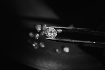 close up photo of round Diamond in Tweezers