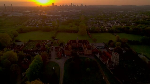 Drone pulls back from Carew Manor to reveal skyline of Croydon at dawn, UK