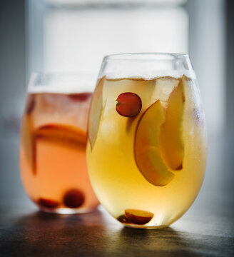 Two glasses of red and white sangria with fruit.