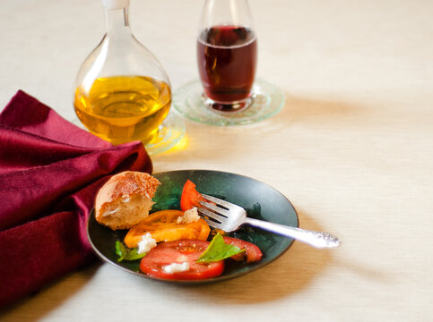 Caprese salad with tomatoes, basil, mozzarella, bread, oil and vinegar