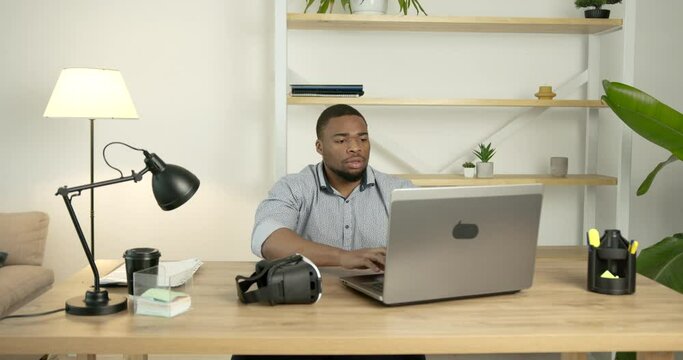 Young black man wears virtual reality glasses at office