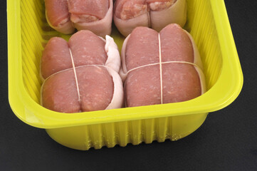 Barquette de paupiettes de veau en gros plan sur fond noir