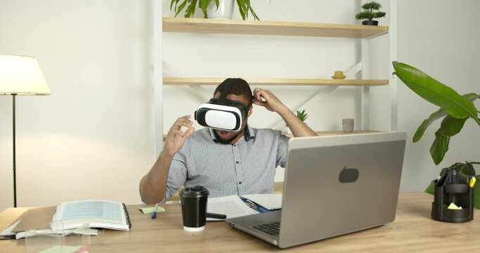 Young black man wears virtual reality glasses at office