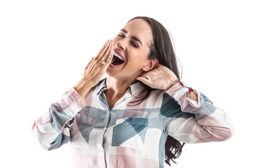 Sleepy and tired woman yawns with mouth wide open and a hand in front of her mouth.