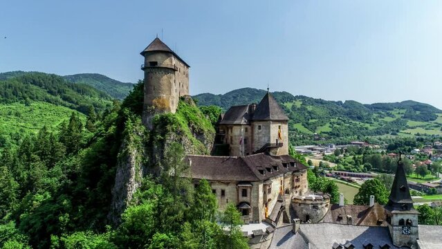 Orava castle - Oravsky Hrad in Oravsky Podzamok village in Slovakia. Medieval stronghold on extremely high and steep cliff by the Orava River. Aerial 4K panning video in summer