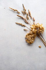 Still life mockup, dry grass, dried flowers. Beige table background. Flatlay, copy space