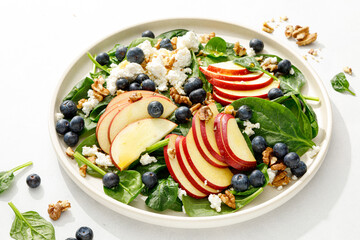Apple and spinach fresh sweet fruit salad with blueberry, cheese cottage and walnuts