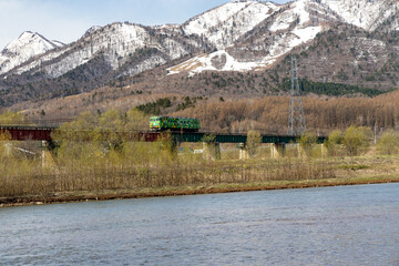 雪山をバックに北の大地の自然の中に作られた単線の単線を走る一両編成の気動車