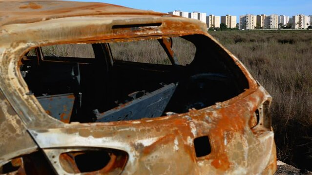 A vintage, rust car abandoned outside the city limits and left to decay