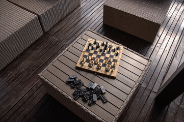 Chess and dominoes on the wooden table on the terrace.