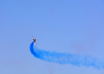 Military fighter planes fly in a group with smoke in the blue sky