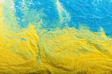 Ukrainian flag colours. The concept of war in Ukraine. Blue and yellow background from holi powder paint.