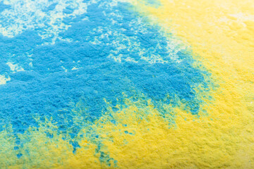 Ukrainian flag colours. The concept of war in Ukraine. Blue and yellow background from holi powder paint.