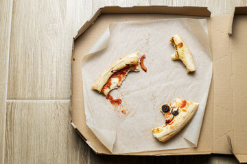 empty cardboard pizza box with pizza leftovers. After meal. Dirty dishes after dinner.