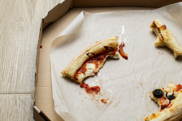 empty cardboard pizza box with pizza leftovers. After meal. Dirty dishes after dinner.