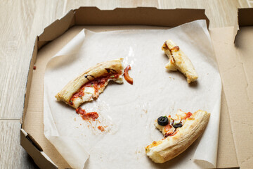 empty cardboard pizza box with pizza leftovers. After meal. Dirty dishes after dinner.