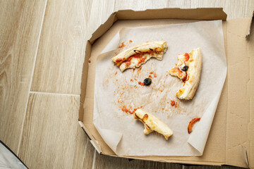 empty cardboard pizza box with pizza leftovers. After meal. Dirty dishes after dinner.