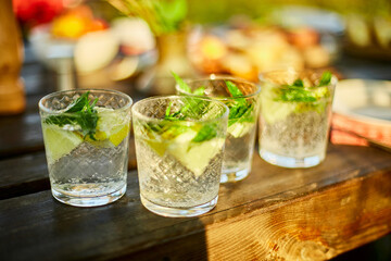 Summer citrus lemonade on the wooden table outdoor, party in a backyard house with сold drinks, Served table, summertime.