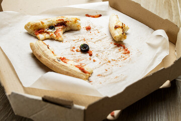 empty cardboard pizza box with pizza leftovers. After meal. Dirty dishes after dinner.