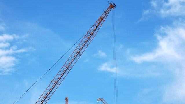  4K large construction site with several busy cranes at dusk with clear blue sky