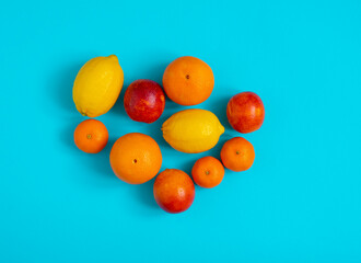 Citrus fruits: orange, lemon, tangerine, blood orange laid out on a blue background
