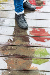 black shoes on wet wooden floor with umbrella reflection