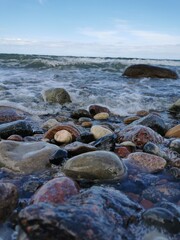 Fototapeta na wymiar Bunte Steine im Wasser Welle Ostsee Gespensterwald